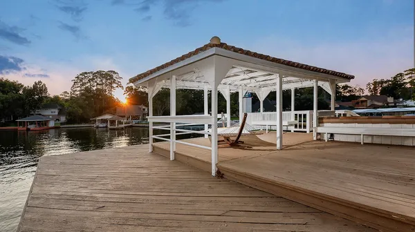 a view of a house with wooden deck next to a lake