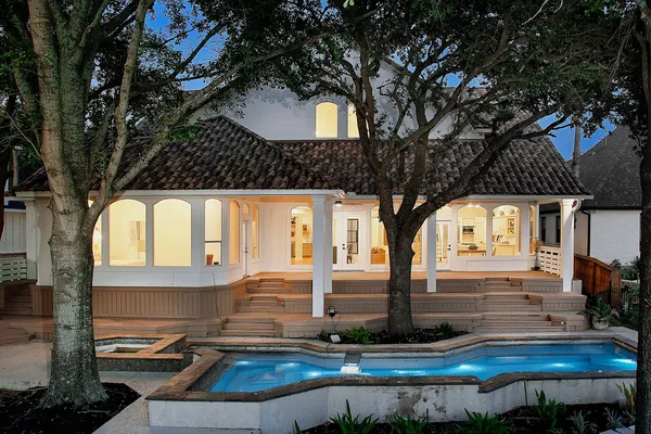 a front view of a house with trees and backyard