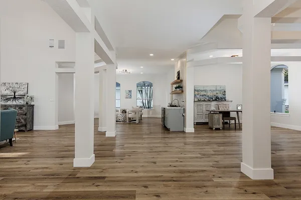 a kitchen with stainless steel appliances kitchen island granite countertop a stove a sink a refrigerator and white cabinets