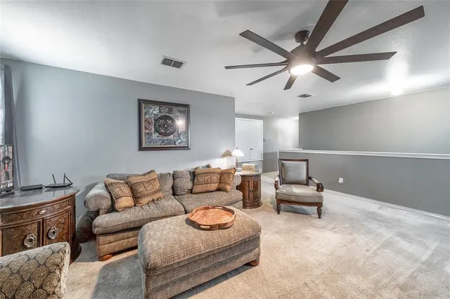 a living room with furniture and a ceiling fan