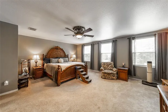 a bedroom with a bed a large window and couch