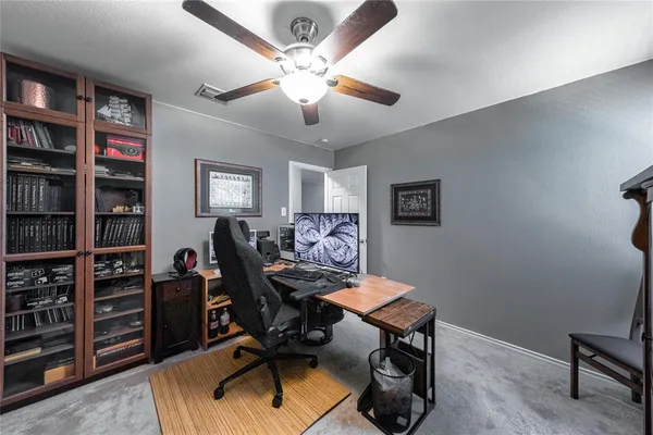 a view of a workspace with furniture and a bookshelf