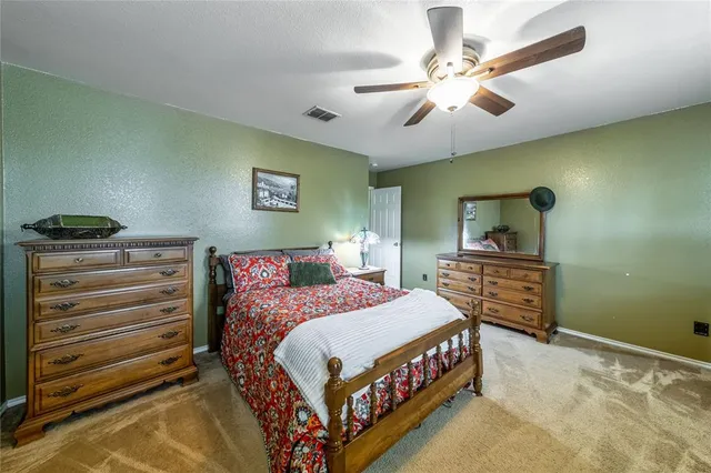 a bedroom with a bed a chandelier and a dresser