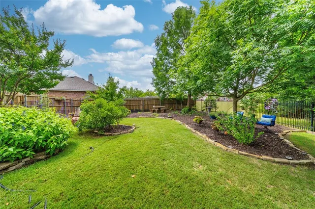 a view of backyard with table and chairs and potted plants