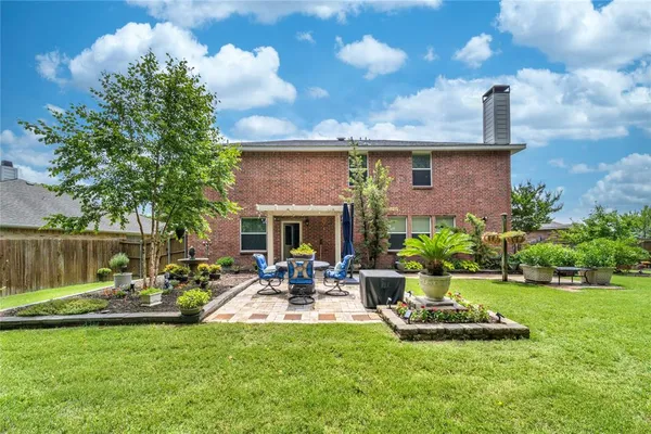 a front view of a house with garden and a patio