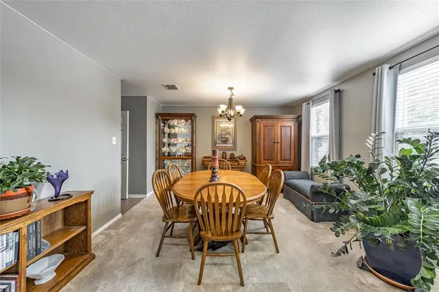 a view of a dining room with furniture and chandelier
