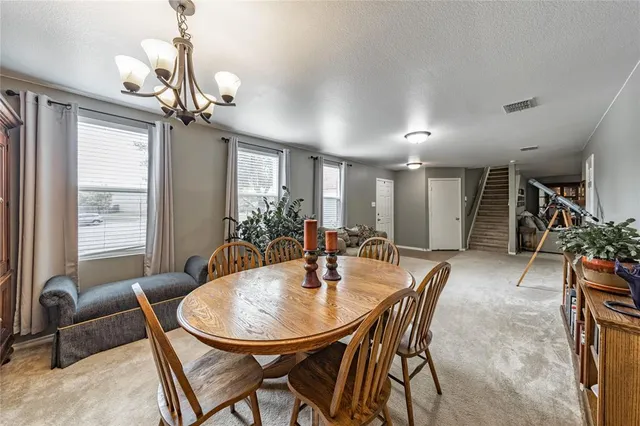 a view of a dining room with furniture and a chandelier