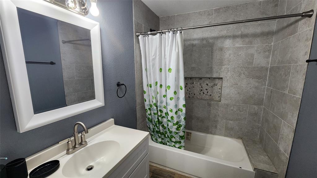 809 Bowie Street Sweetwater, TX 79556 - Photo 11 of 20 Full bathroom featuring shower / bath combo, vanity, and a textured wall