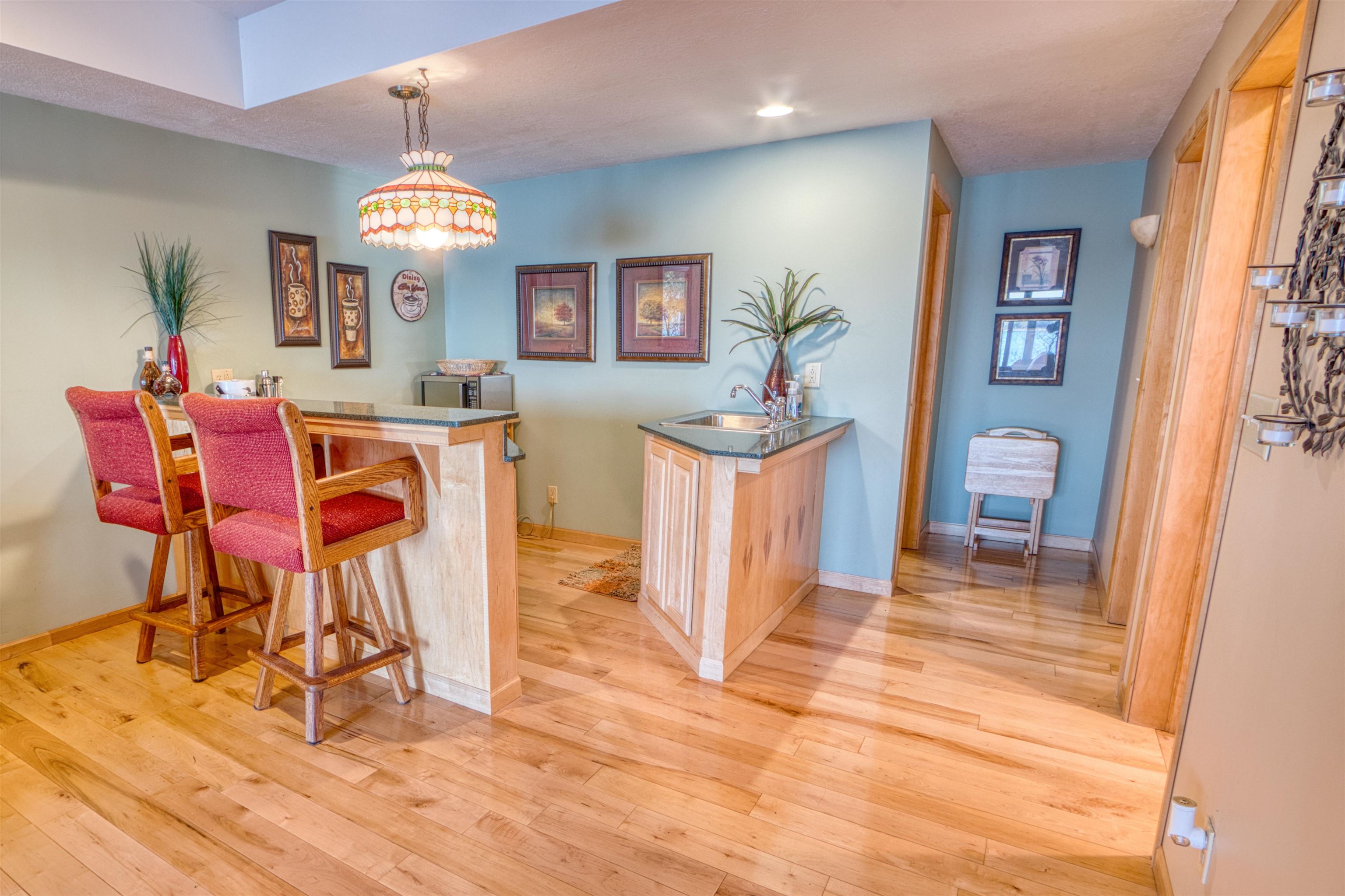 14366 North One Mile Road Minong, WI 54859 - Photo 36 of 40 Bar with recessed lighting, a sink, light wood-style floors, baseboards, and pendant lighting
