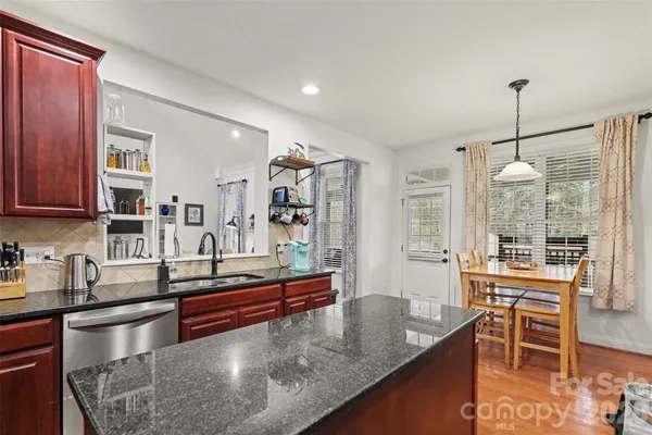 a kitchen with granite countertop a sink appliances and cabinets