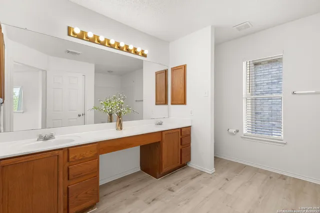 a spacious bathroom with a granite countertop sink a mirror and a