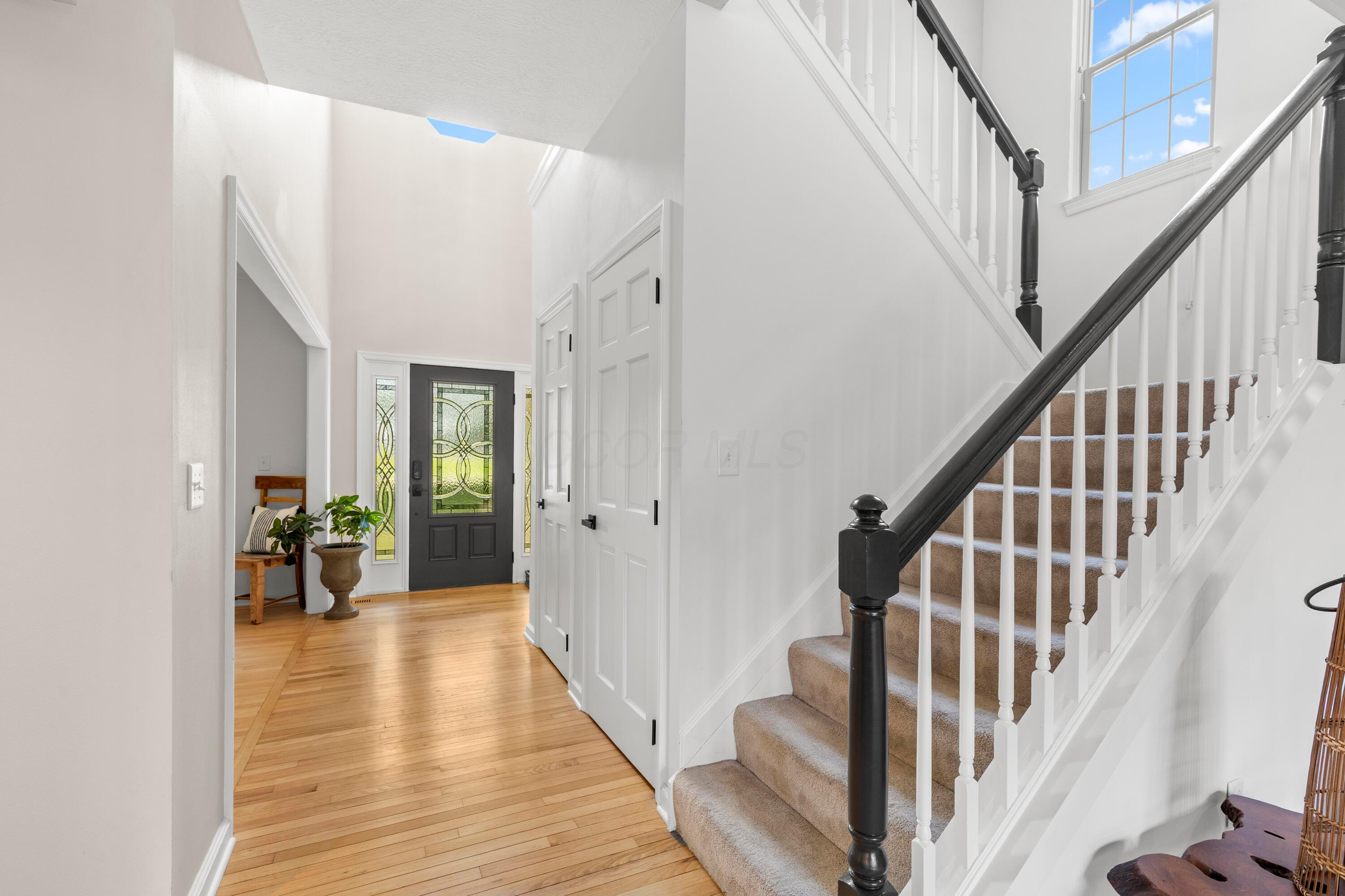 1515 Dale Ford Road Delaware, OH 43015 - Photo 10 of 74 • Hardwood flooring • Ivory painted walls • Two-story ceiling • Chandelier • Single door closet