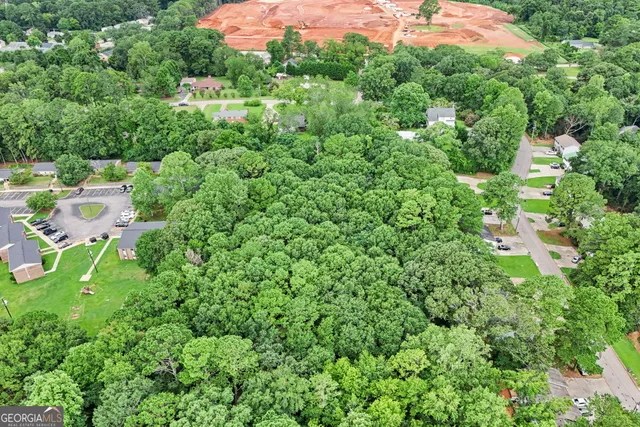 an aerial view of residential house with outdoor space and trees all around