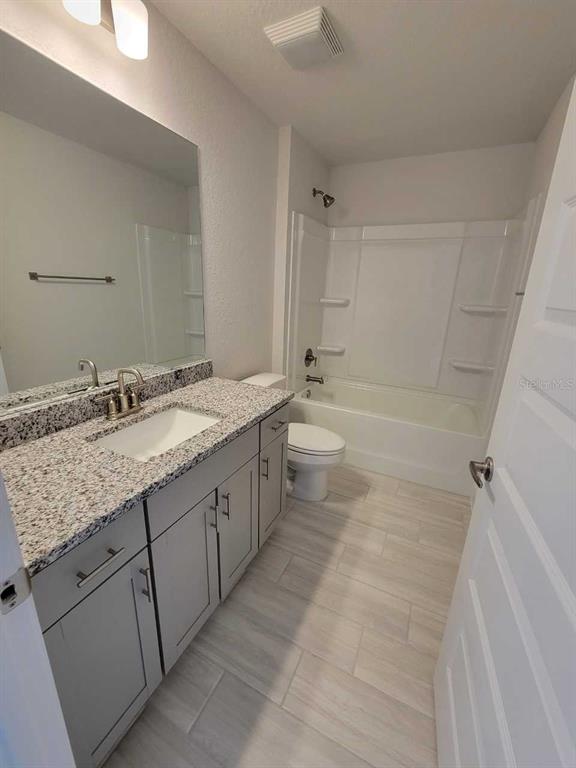4525 Southwest 91st Ln Road Ocala, FL 34476 - Photo 17 of 20 a spacious bathroom with a granite countertop sink mirror vanity and toilet