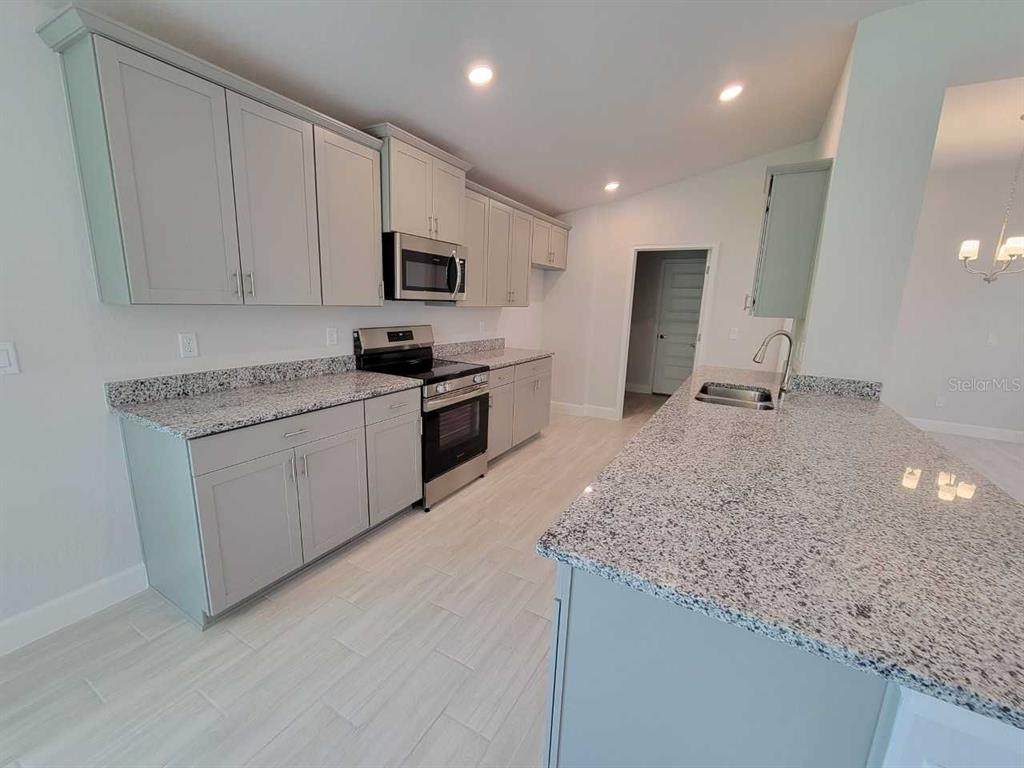 4525 Southwest 91st Ln Road Ocala, FL 34476 - Photo 8 of 20 a kitchen with stainless steel appliances granite countertop a sink stove and microwave