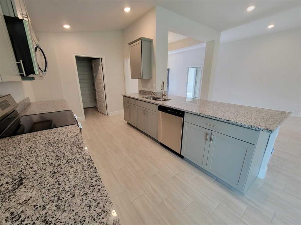 4525 Southwest 91st Ln Road Ocala, FL 34476 - Photo 10 of 20 a large kitchen with stainless steel appliances kitchen island granite countertop a sink and a granite counter tops