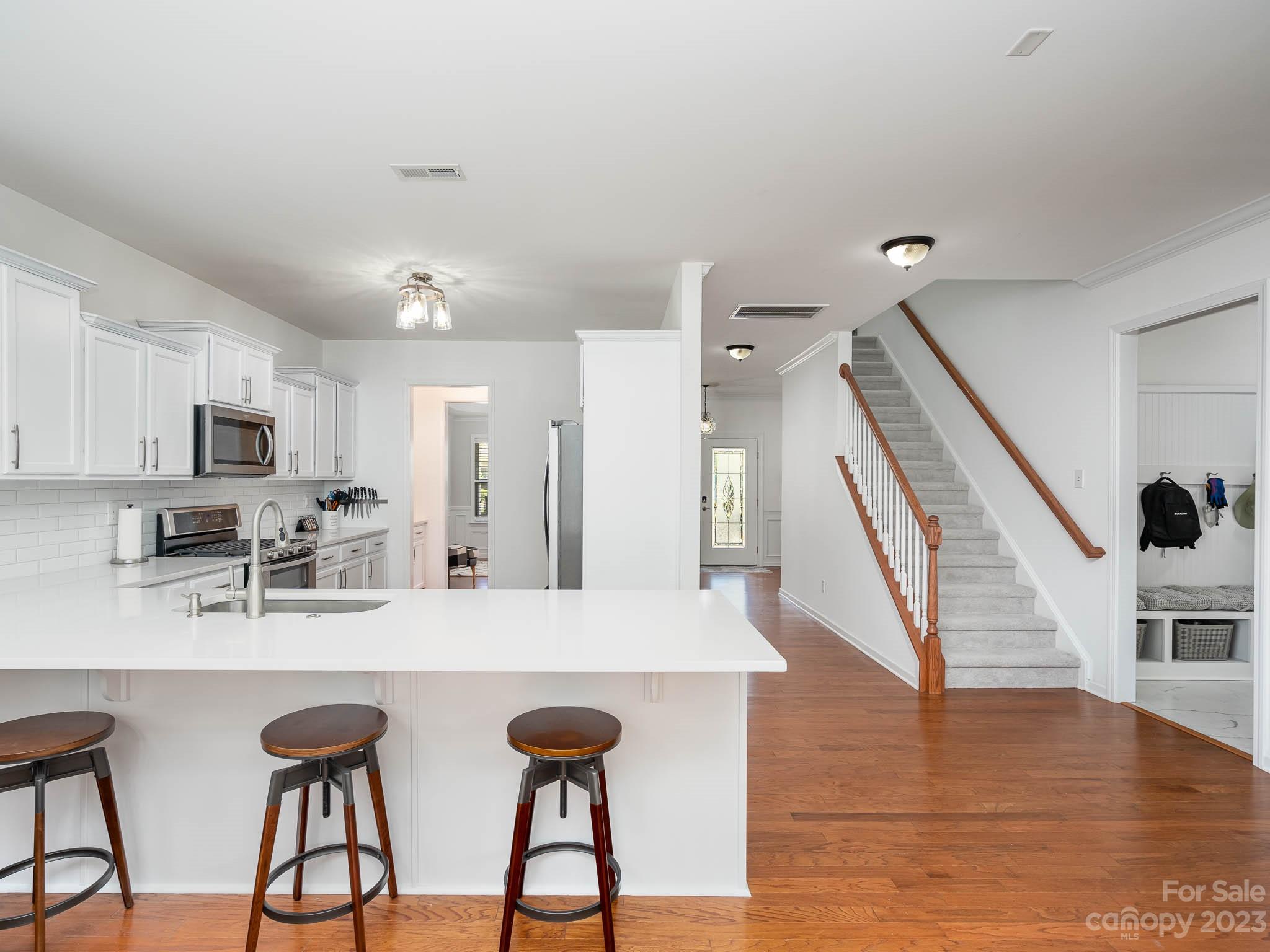 2185 Bluebell Way Tega Cay, SC 29708 - Photo 13 of 45 a kitchen with stainless steel appliances granite countertop a dining table chairs and white cabinets