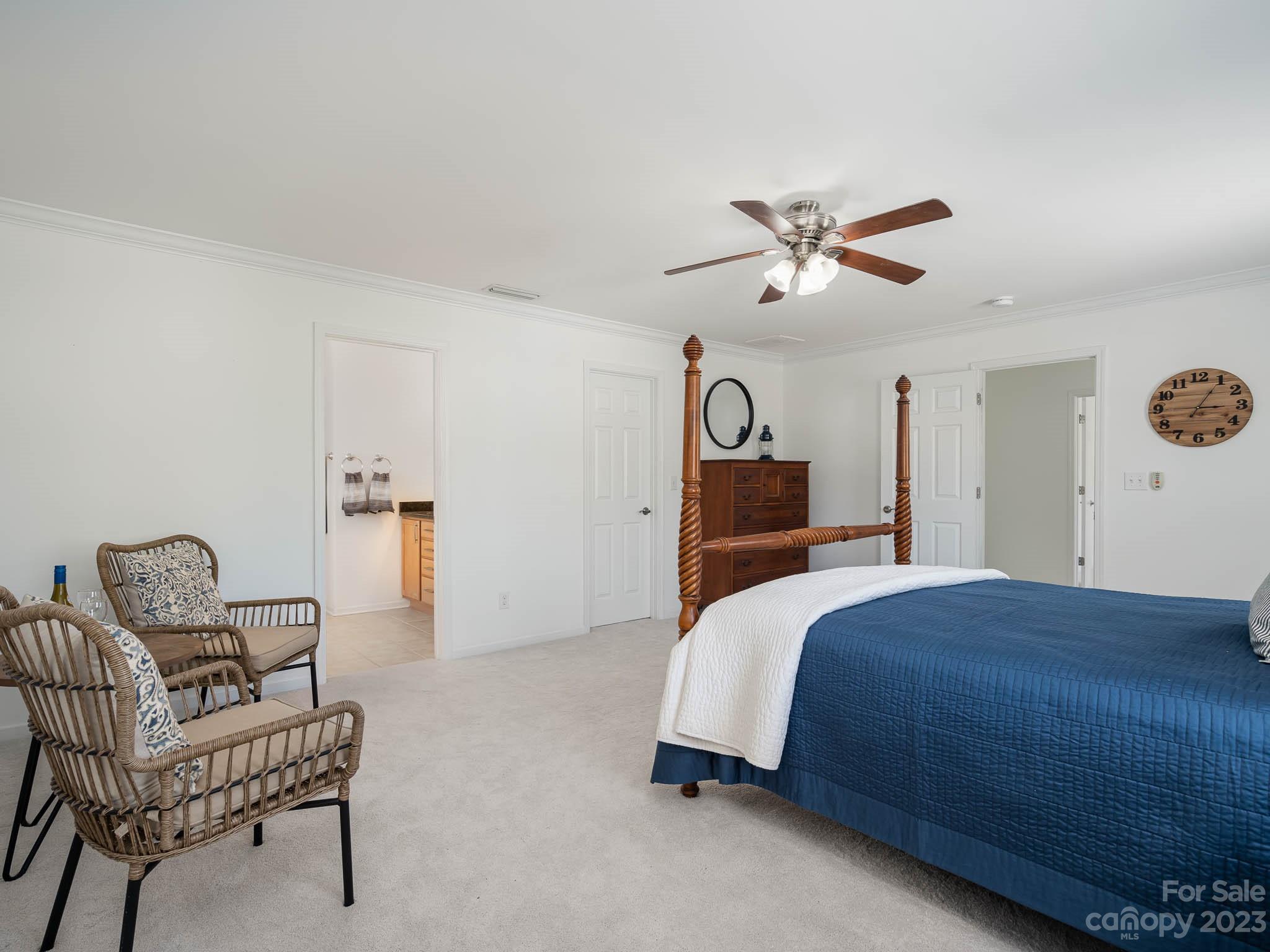 2185 Bluebell Way Tega Cay, SC 29708 - Photo 23 of 45 a bedroom with a bed a chair and a chandelier