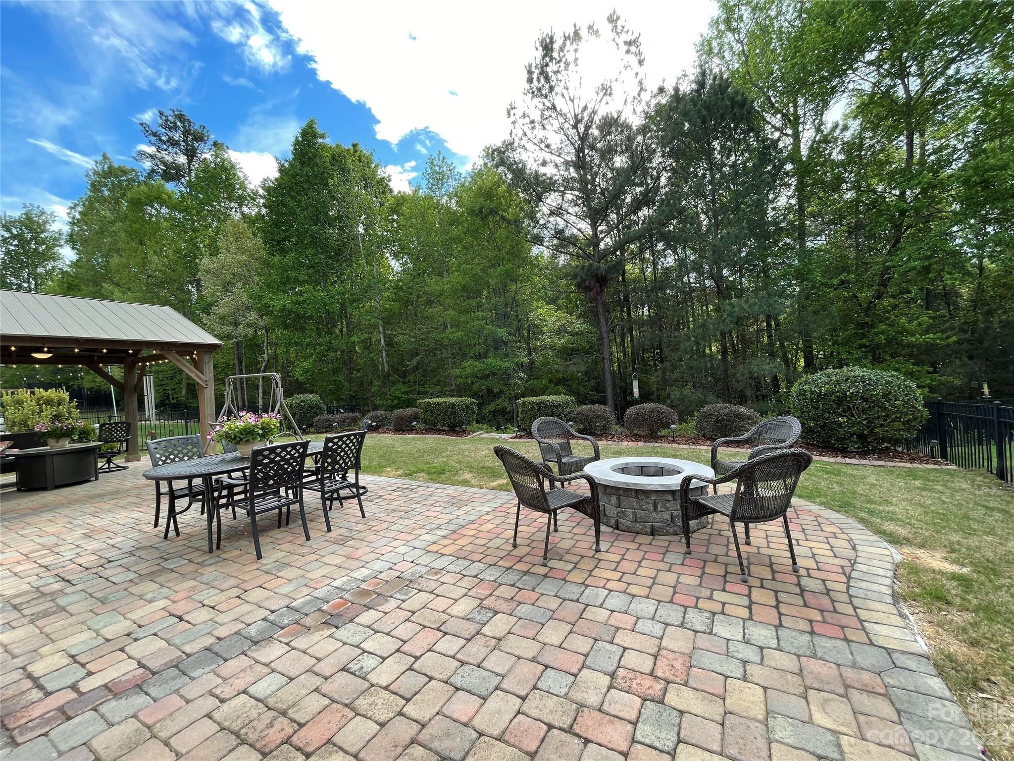 2185 Bluebell Way Tega Cay, SC 29708 - Photo 35 of 45 a view of a patio with table and chairs potted plants with wooden fence