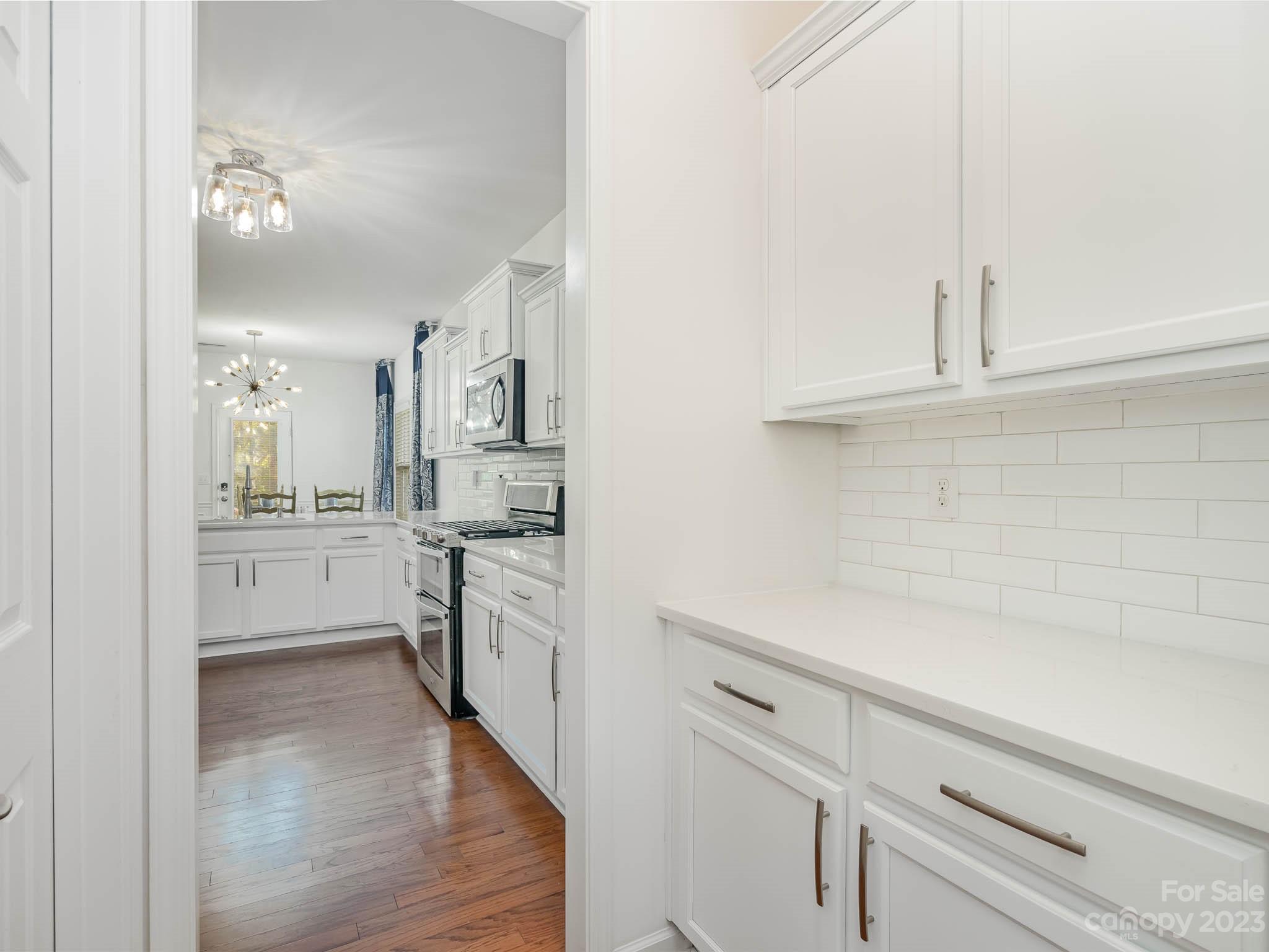 2185 Bluebell Way Tega Cay, SC 29708 - Photo 8 of 45 a open kitchen with white cabinets and stainless steel appliances