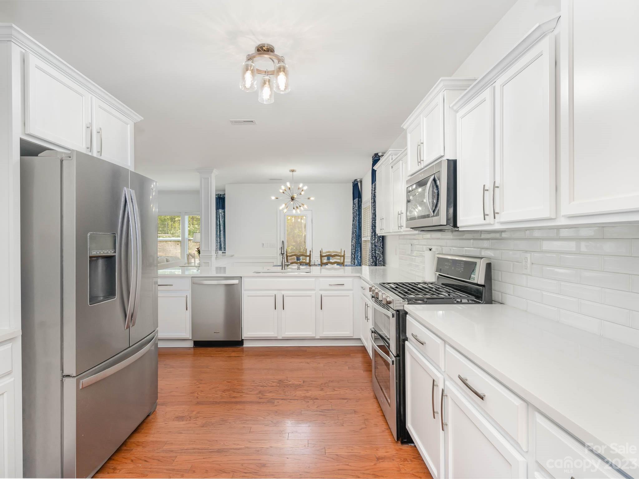 2185 Bluebell Way Tega Cay, SC 29708 - Photo 10 of 45 a kitchen with white cabinets and stainless steel appliances