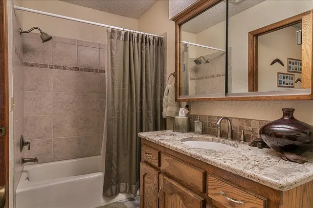 a bathroom with a granite countertop toilet and a sink