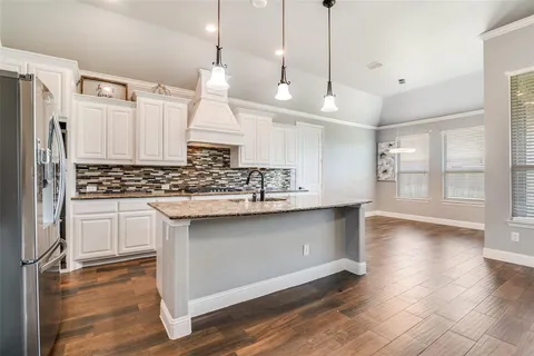 a kitchen with white cabinets and appliances
