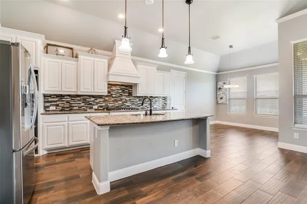 a kitchen with white cabinets and appliances