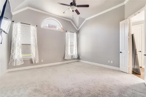 en empty room with windows and ceiling fan