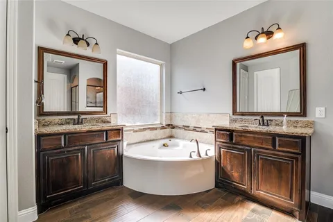 a bathroom with a tub sink and mirror