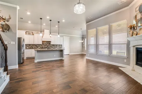 a large kitchen with stainless steel appliances kitchen island granite countertop a large cabinets a sink and a stove