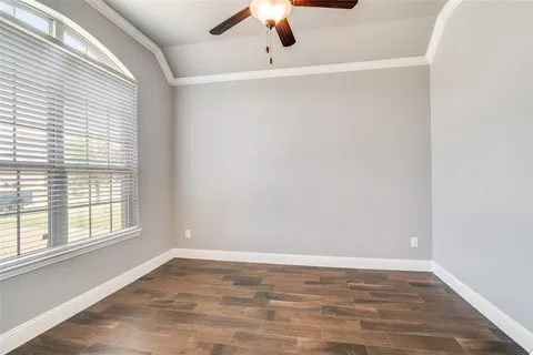 an empty room with a window and a ceiling fan