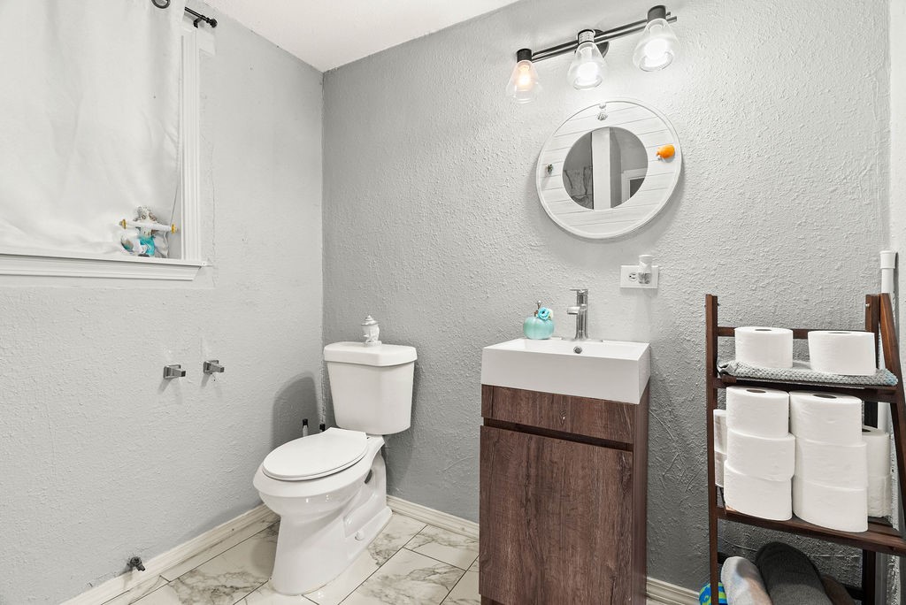 647 West Main Avenue Robstown, TX 78380 - Photo 12 of 16 a bathroom with a toilet a sink and a mirror