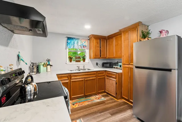 a kitchen with stainless steel appliances a refrigerator sink and white cabinets