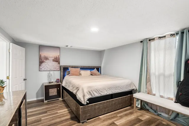 a bedroom with a bed lamp and a window