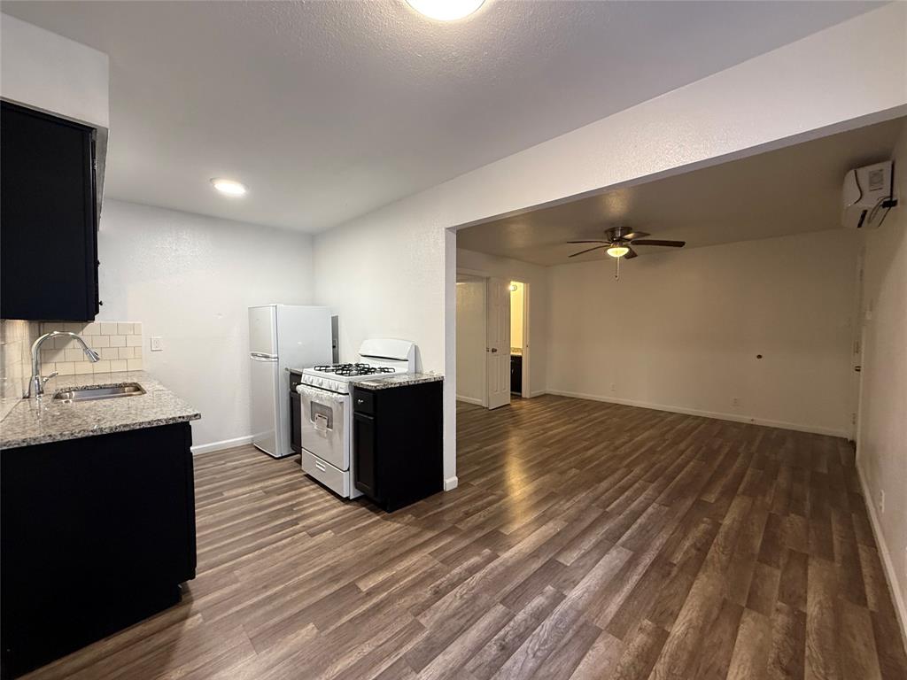 a kitchen with a sink and wooden floor