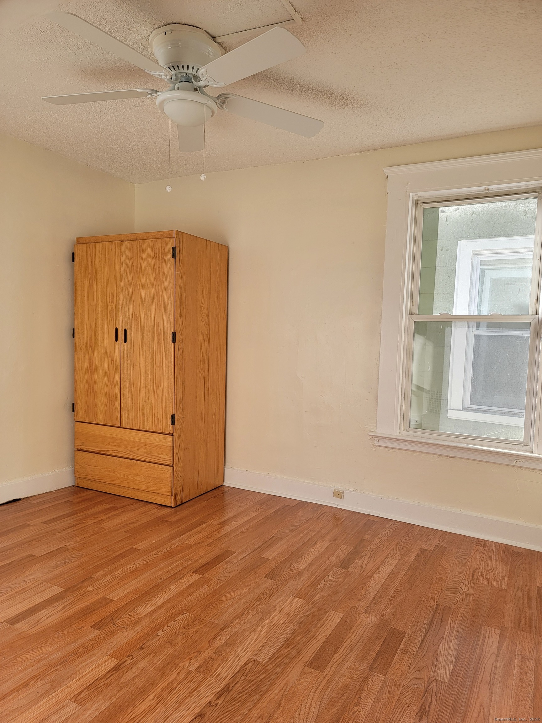 322 Bassett Street, Unit 2 New Haven, CT 06511 - Photo 11 of 14 an empty room with wooden floor cabinet and windows
