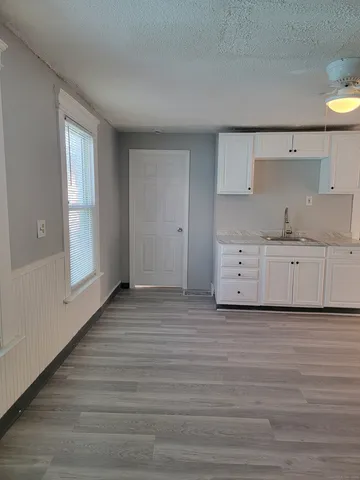 a view of a kitchen with wooden floor and cabinets