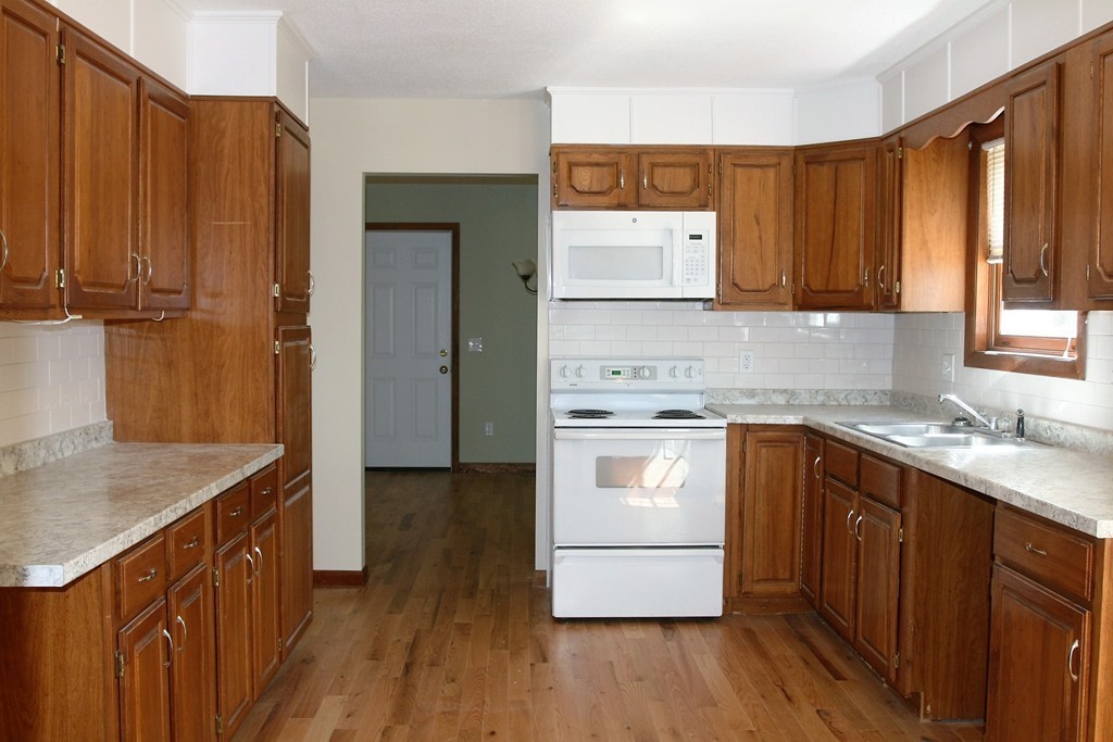 100 Signal Hill Circle Springfield, MA 01118 - Photo 5 of 19 a kitchen with a sink a stove cabinets and wooden floor