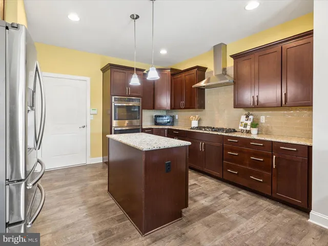 a kitchen with stainless steel appliances granite countertop a sink a stove and refrigerator