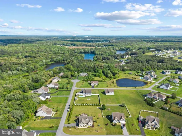 a aerial view of a house with swimming pool big yard and a fountain