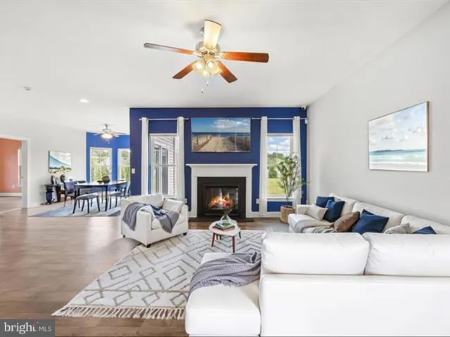 a living room with furniture a large window and a fireplace