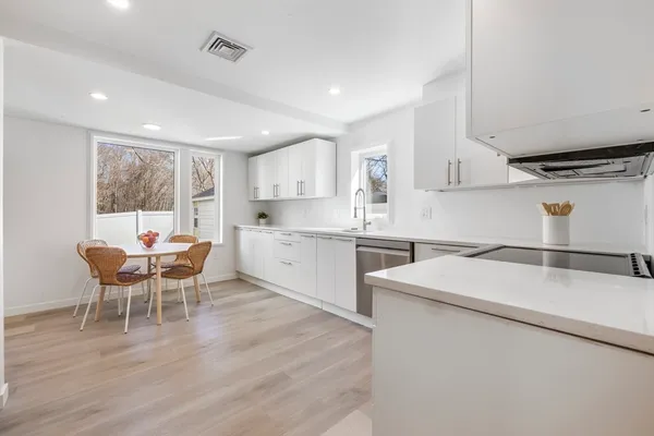 a kitchen with stainless steel appliances white cabinets and a refrigerator