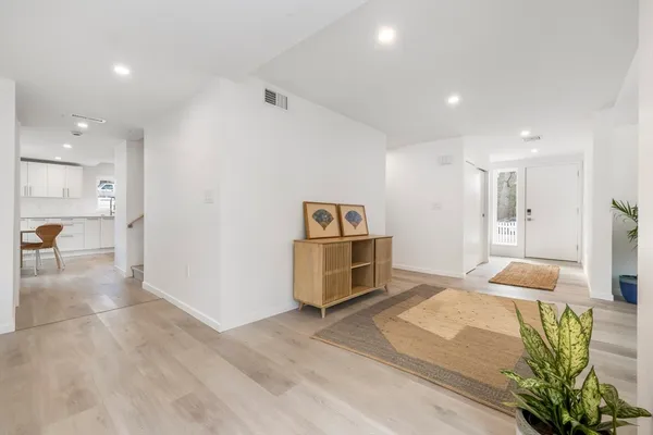 a kitchen with stainless steel appliances granite countertop a dining table chairs microwave and sink