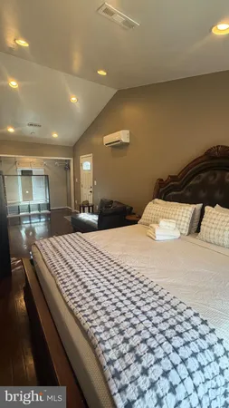a large bedroom with a bed and a large mirror