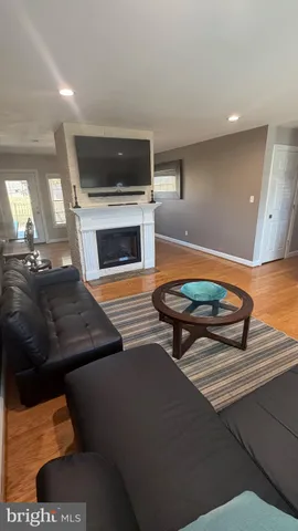 a living room with pool table a fireplace and windows