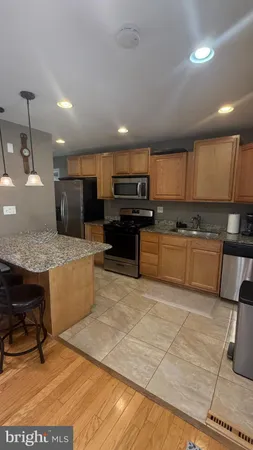 a large kitchen with kitchen island a stove a sink a counter top space and cabinets