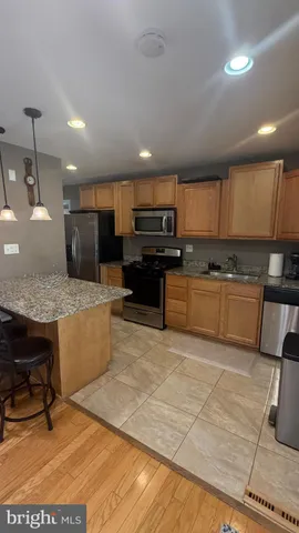 a large kitchen with kitchen island a stove a sink a counter top space and cabinets