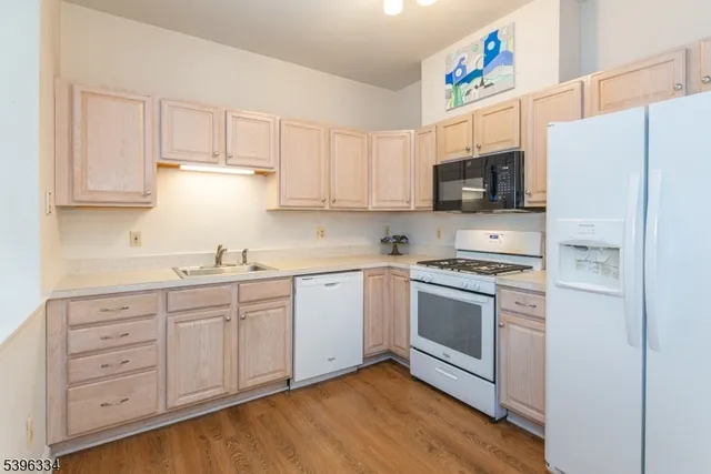 a kitchen with granite countertop white cabinets and white appliances
