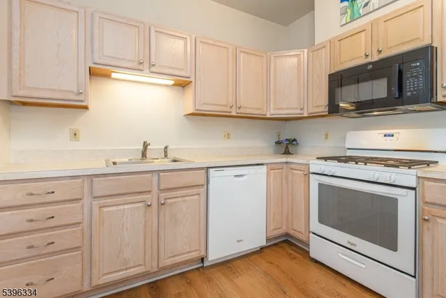 a kitchen with white cabinets stainless steel appliances and sink